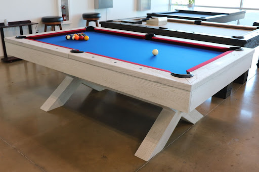 Custom pool table with blue felt, white wood frame, and red rails.